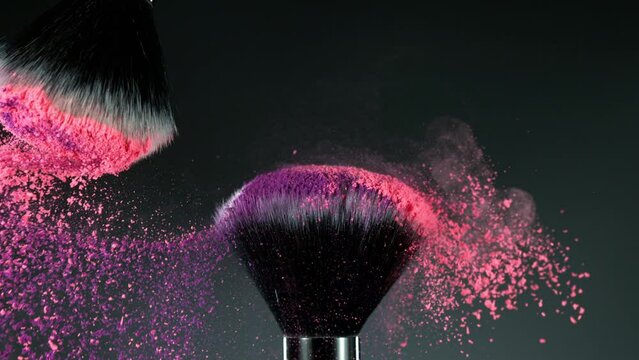 Super slow motion of makeup brushes with flying colored powder. Filmed on high speed cinema camera, 1000fps. Speed ramp effect.