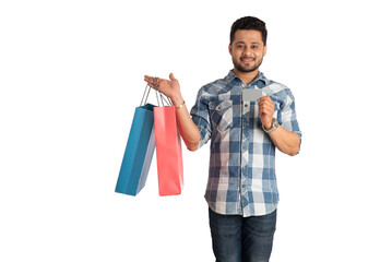 young man holding and posing with shopping bags with credit or debit card on a white background