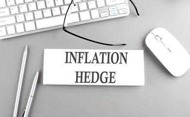 INFLATION HEDGE text on paper with keyboard on grey background