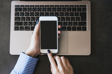 ノートパソコンとスマートフォンを操作する女性