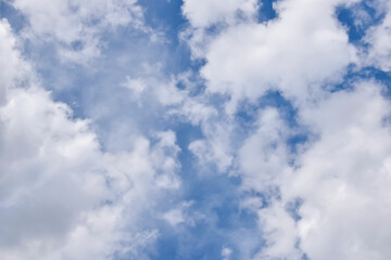 Beautiful cloudy sky. Blue sky with lots of white fluffy cumulus clouds, natural background, full frame. Selective focus.