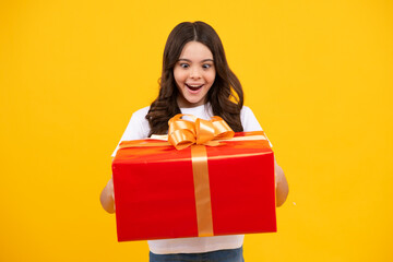 Amazed teenager. Emotional teenager child hold gift on birthday. Funny kid girl holding gift boxes celebrating happy New Year or Christmas. Excited teen girl.