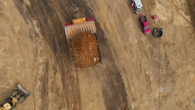 top view of a loaded with ground big quarry dump truck. synchronous flight by drone