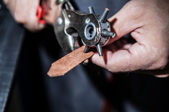 Working process of leather craftsman. Tanner or skinner sews leather on a special sewing machine, close up.worker sewing on the sewing machine
