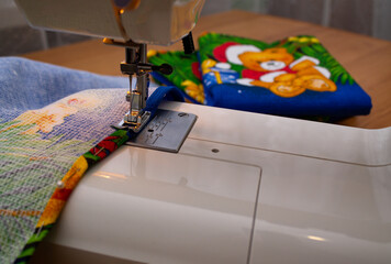 Partly depicted is a sewing machine on which festive New Year's towels are sewn.
