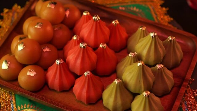 Close-up shot in slow motion. Ladu modaka dessert for Lord Ganesha on a tray ready to be worshiped. indian sweets