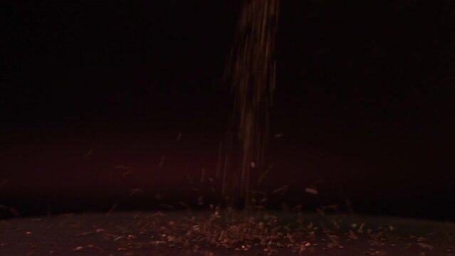 Close-up shot in slow motion. In the kitchen, preparing ingredients for cooking. Whole grains were sprinkled on a slowly rotating black tray.