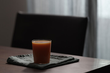 Pumpkin carrot juice mix in a glass on wood table