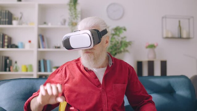 Elderly man wearing virtual reality googles in modern interior design, leisure