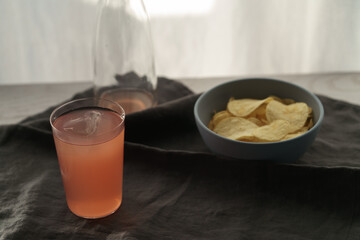 Pink drink with potato chips in a bowl on linen napkin