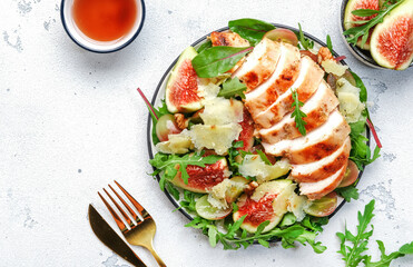 Grilled chicken fillet with fig, grape, arugula and chard salad. White kitchen table background, top view