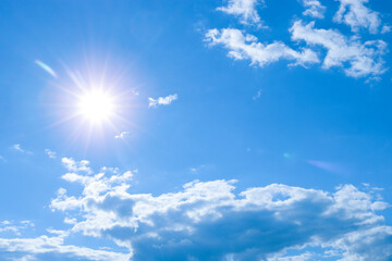 Naklejka na ściany i meble Blue sky with clouds and bright sun. Weather, atmosphere, season.