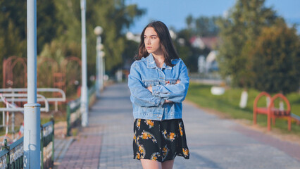 A lonely girl walks along the city's promenade.