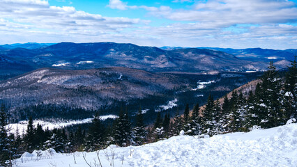 View in winter on the snow covered mountains of Laurentides from the top of Mount Kaaikop in Quebec...