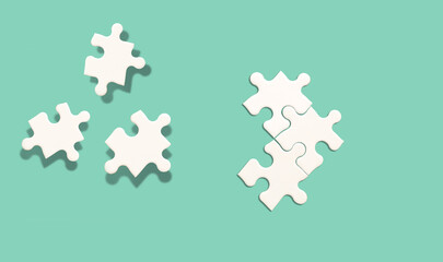 White jigsaw puzzle on green background, Find the right joined team idea and fit correctly concept