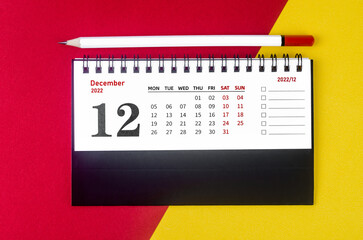 The December 2022 Monthly desk calendar for 2022 year with white pencil on beautiful background.