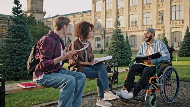 Multiracial students check reports in university campus