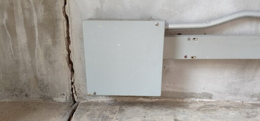 Cracks in the cement wall with long and deep lines near the electrical control box. This may be due to improper mixing of mortar or soil subsidence. Cracks can cause concern for users.
