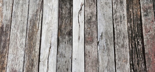 Pattern of an old wooden floor. Small wooden slats with different patterns are stacked together to form a fence or bridge.
