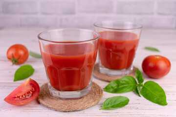 Tomato juice decorated with basil leaves.	