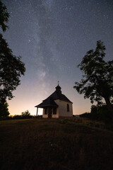 Fototapeta premium Milchstraße Sternenhimmel über Kirche Kapelle Kleine Kalmit im Sternenpark Pfälzerwald