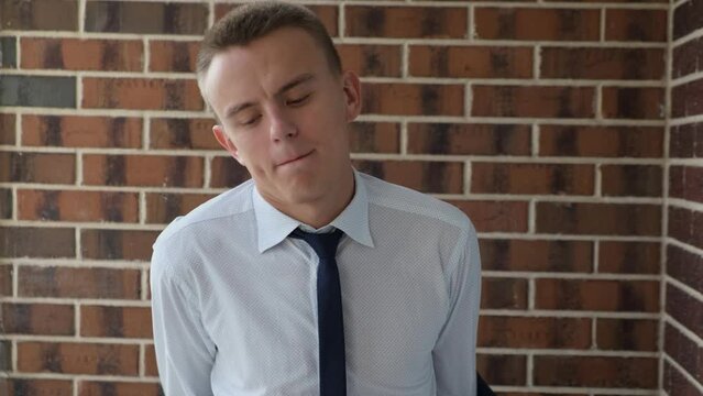 Tired businessman taking off his jacket and unbuttoning his tie