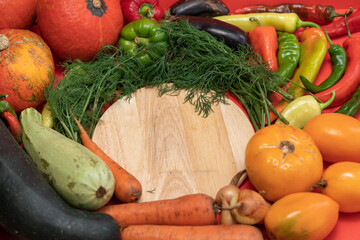 Vegetables are laid out around empty place. Empty space for text. Vegetables on a wooden board.