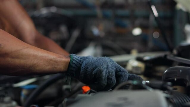 Closeup hand and spanner. Engineer mechanic male repairs and service car in garage. Car maintenance and auto service garage concept.