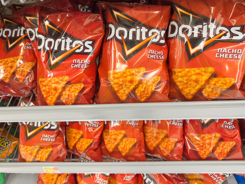 Houston, Texas, USA - February 22, 2022: DORITOS Nacho Cheese Flavored Tortilla Chips bags on the shelf in a supermarket. 
