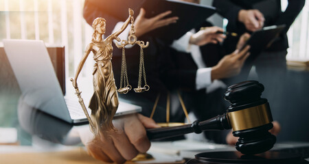 Judge gavel with Justice lawyers having team meeting at law firm in background. Concepts of law.