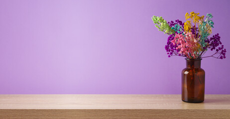 Autumn dried flowers decoration on wooden table over purple violet background. Thanksgiving holiday mock up for design and product display
