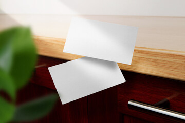Clean minimal business card mockup floating on top table with leaves