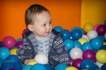 Fototapeta na wymiar Cute kid or child playing colorful balls top view