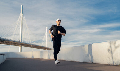 Male runner trains active running in the city, sportswear and sneakers.
