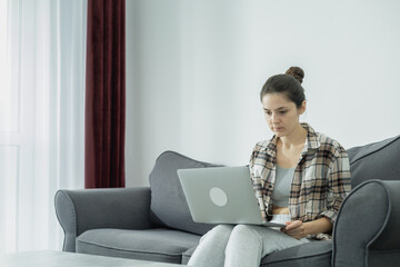 Fototapeta premium The girl works from home at the computer. I thought about my future. Online shopping in your free time.