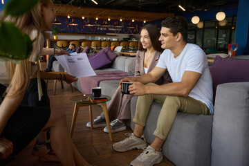 Man and woman involved in discussion of document with colleagues