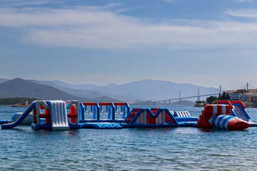 Water attractions on the sea by the beach. In the background is the new bridge on Peljesac in...