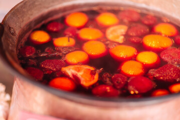 Traditional mulled wine, a winter street drink, prepared and heated in a pot in winter at a street shop