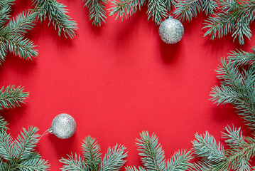 Fototapeta na wymiar Christmas red background from green fir branches, frame, top view 