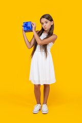 teen girl hold present box on yellow background