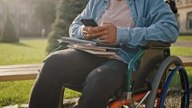 Disabled man sits in wheelchair checking social networks