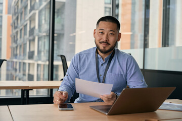 Young entrepreneur sitting at laptop in his office