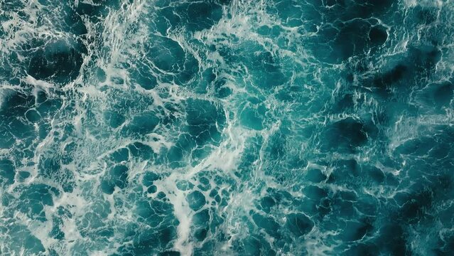 Top down aerial view of beautiful giant blue ocean waves crashing and foaming with white wash background