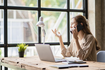 Asian businesswoman working from home, new project, modern loft with laptop, plan analysis,...