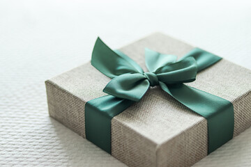 Holiday present and luxury online shopping delivery, wrapped linen gift box with green ribbon on...