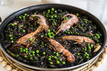 black rice paella with cuttlefish ink, prawns and peas, Majorca, Balearic Islands, Spain