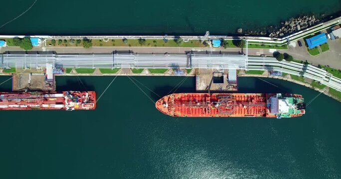 Cargo ships moored to the pier, aerial view. The concept of sea transportation. Tankers at the port, the view from the drone. Logistics of sea cargo transportation. 