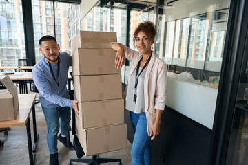 Cheerful young company employees involved in office relocation