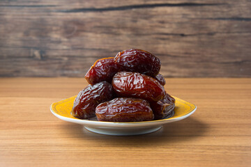 Delicious medjool dates ( kurma ) or sweet dried dates on a plate, as a meal for breaking the fast, ramadan kareem, empty space, copy space.