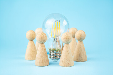 Business concept. Team concept and idea creation. Wooden figures of people stand around coins and a...